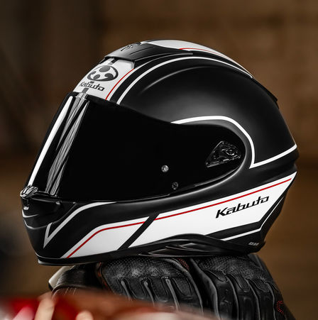Honda Kabuto helmet, Aeroblade V - Smart Flat Black White, left side, sitting on the saddle of a motorcycle