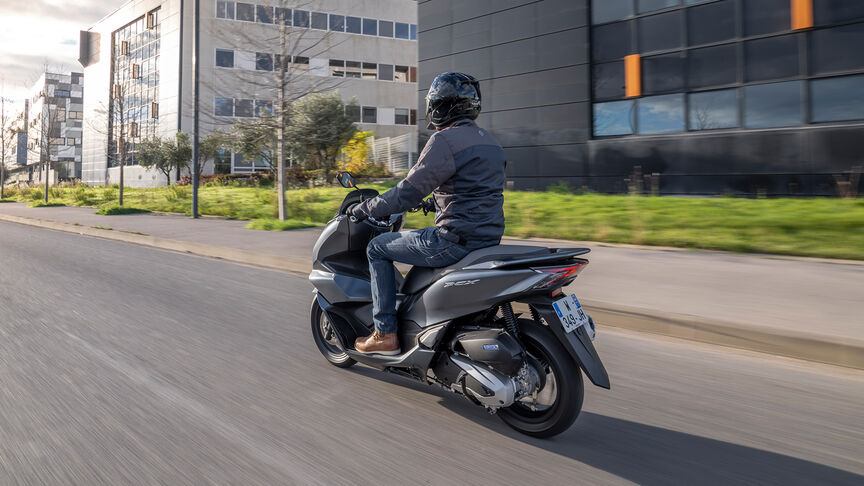 Honda PCX125 – Rear ¾ dynamic shot with rider