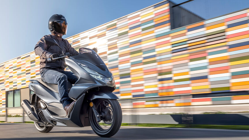 Honda PCX125 – Rear ¾ dynamic shot with rider