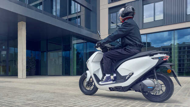 Model riding a Honda CUV e motorcycle demonstrating easy reverse assist.