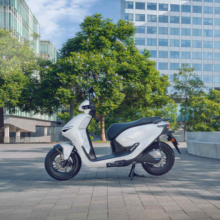 Honda CUV e motorcycle parked in a city location.