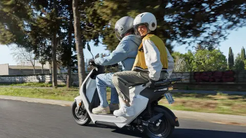 Honda EM1 e: with rider and pillion riding away