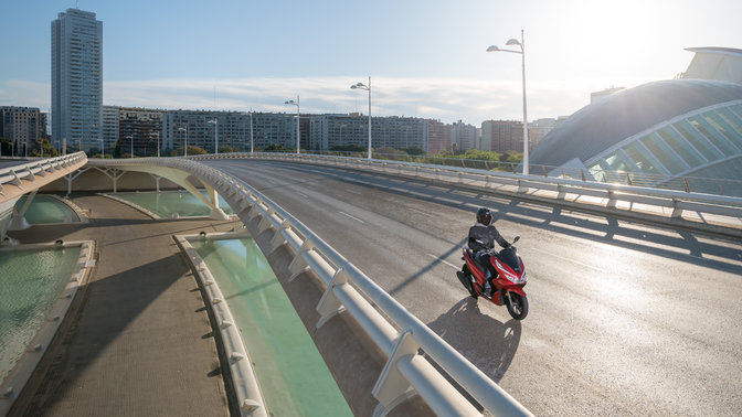 Honda PCX125 being ridden in urban location.