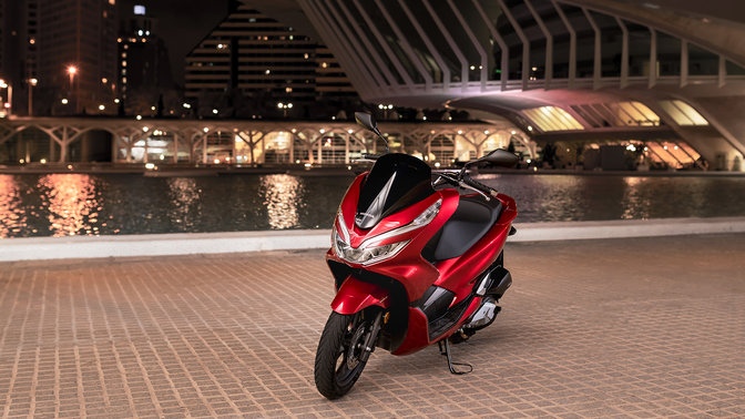 Front three quarters view of Honda PCX125 at a street location.