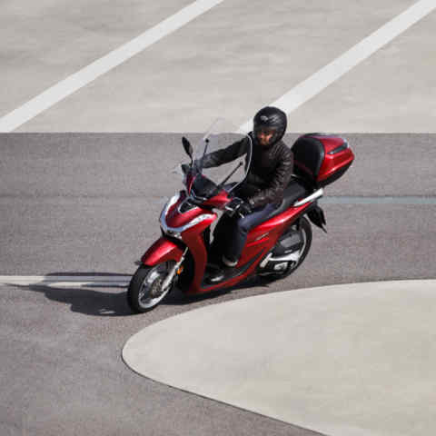 Honda-SH125i, 3-quarter front left side, with rider, left turning in the road