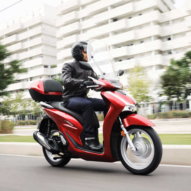 Honda-SH125i 3-quarter front right side, with rider in the city