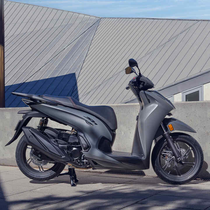 Static side facing Honda SH350i in courtyard location.