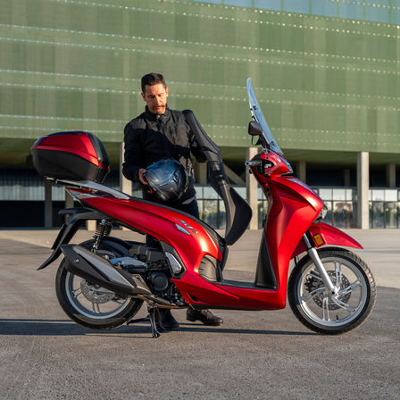 Honda SH350i, man standing next to scooter, rear view, red bike