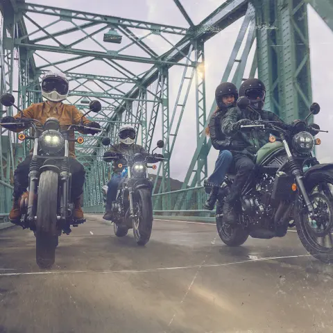 Honda CL500 with three riders on bridge