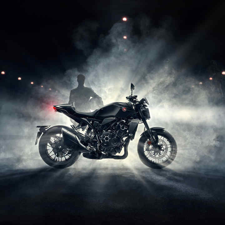 Honda CB1000R - Black Edition - right side, driver behind bike with fog at night, black bike