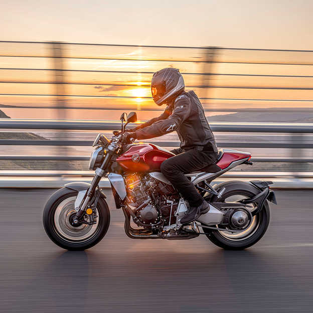 Honda CB1000R, left side, with rider, on the road, with the sunrise