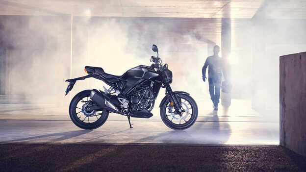 Honda CB300R side facting parked in a garage with a man walking towards the bike.