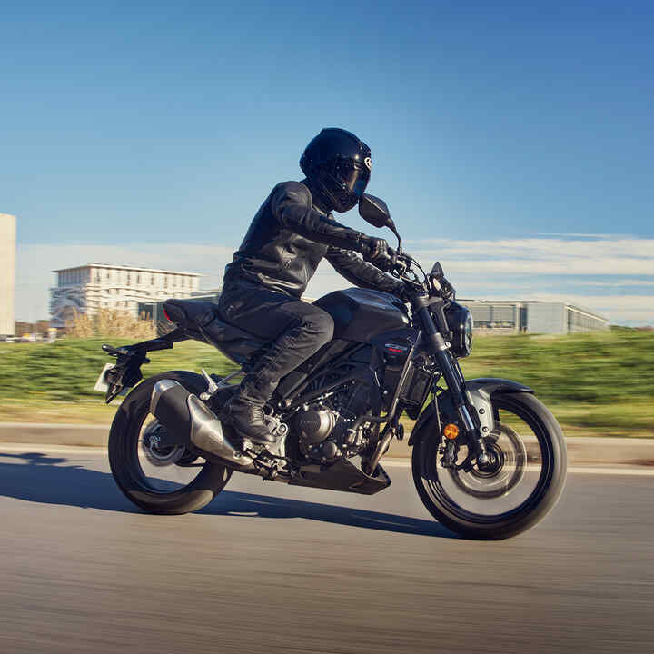 Honda CB300R side facing being riden down the road.