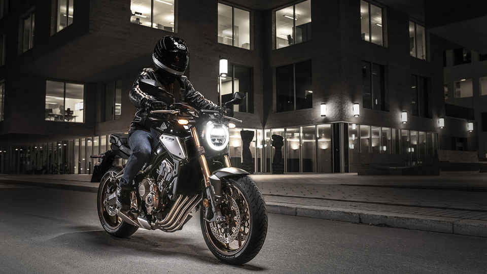 CB650R Neo Sports Café, 3-quarter front right side with rider, in urban landscape at night