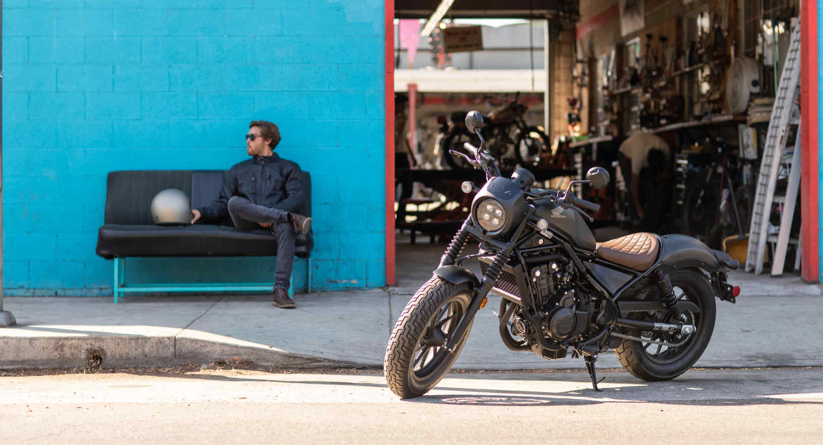 Side facing Honda CMX500 Rebel parked outside workshop.