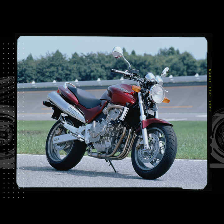 Front facing three quarter Honda Hornet parked on a race track.