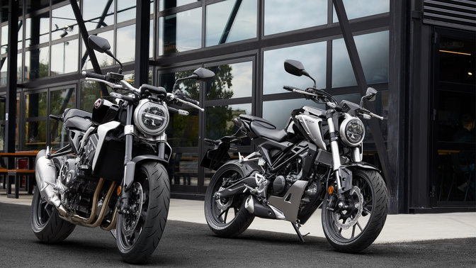photo of a honda cb1000r and cb125r motorbikes parked on a street