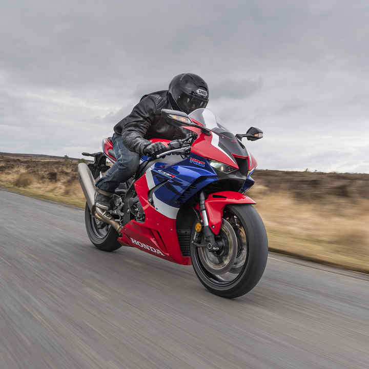Honda CBR1000RR-R Fireblade, 3 quarter front right side, with rider in countryside, road red bike