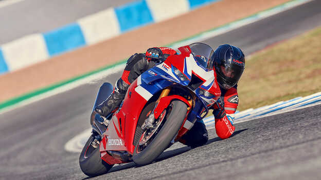 Honda CBR1000rr-r Fireblade dynamic shot on track with rider accelerating out of corner.