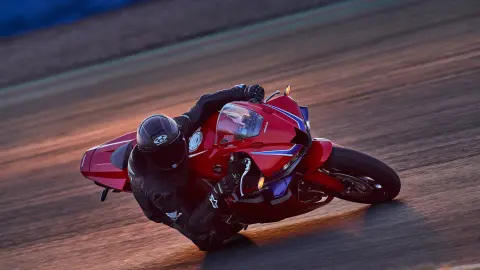 CBR600RR on track with rider in corner.