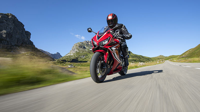 CBR650R, 3-quarter front left side, rolling with rider on a mountain road