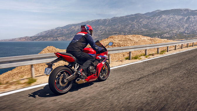 Rider on rear facing Honda CBR650R on the road. 