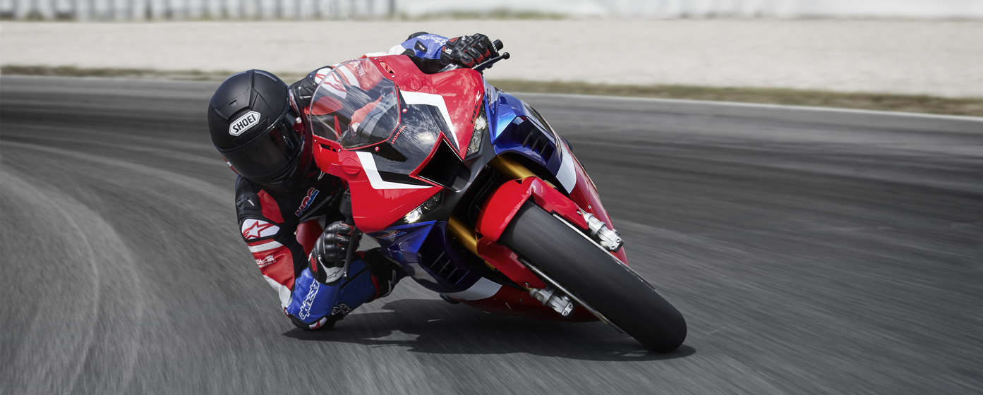 front view of a rider knee-down riding on a red honda cbr1000rr-r fireblade sp super sport motorcycle on a track