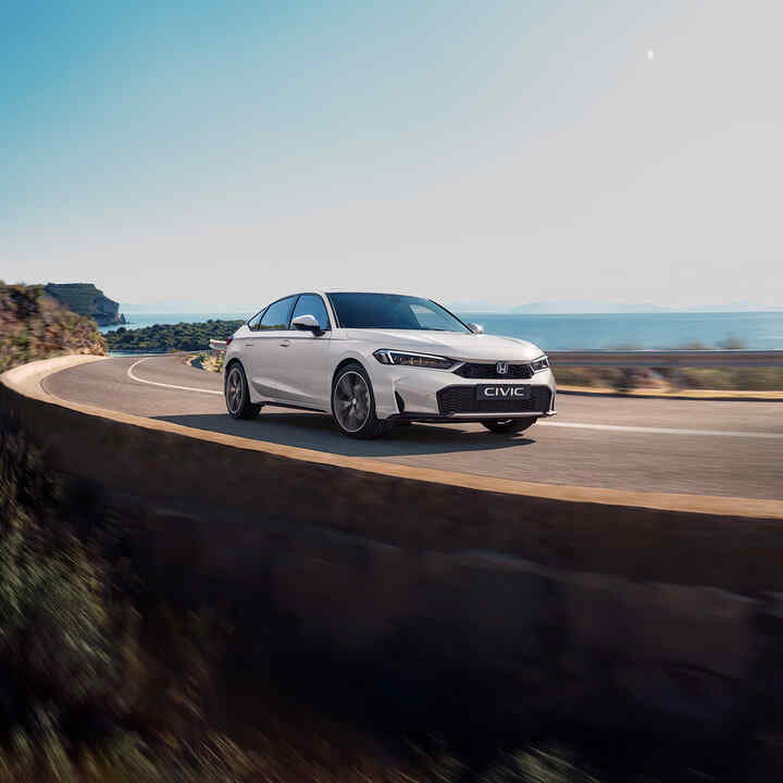 Front three quarter Honda Civic hybrid, sunset, bridge scene.