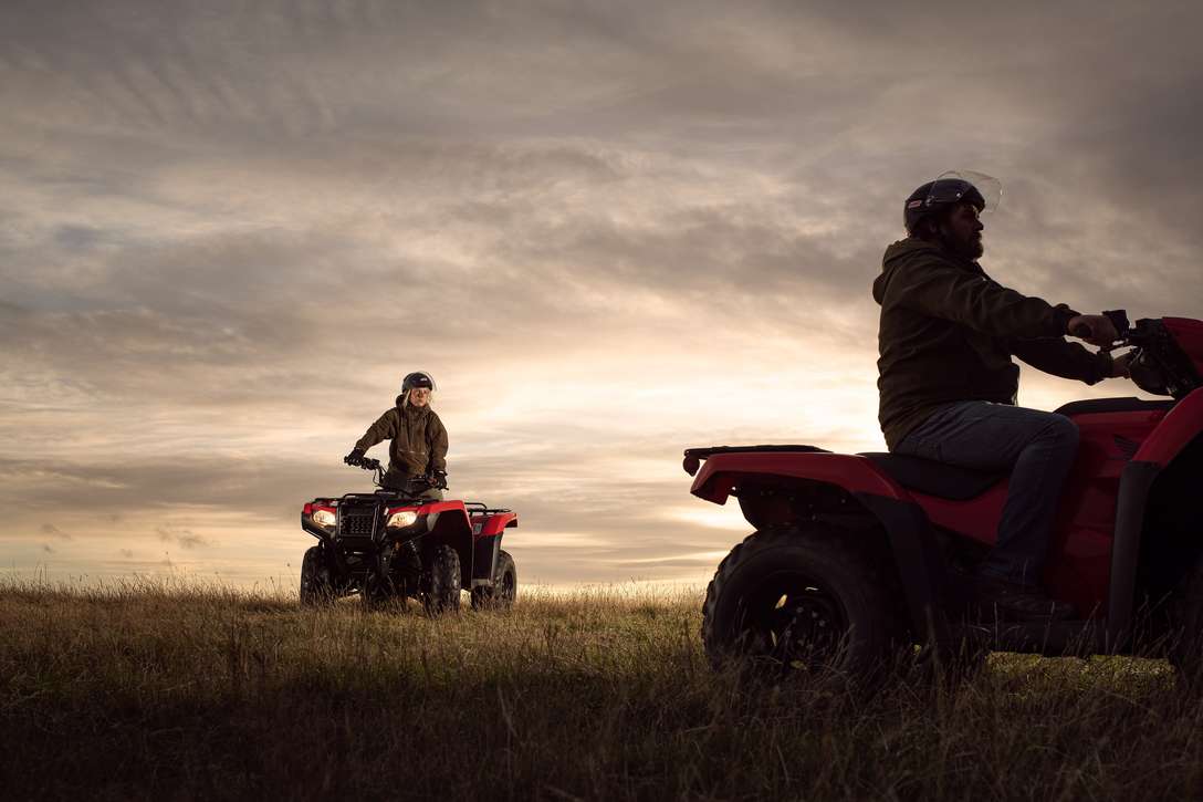 Front three-quarter, right facing Fourtrax 420, being used by model, field location.