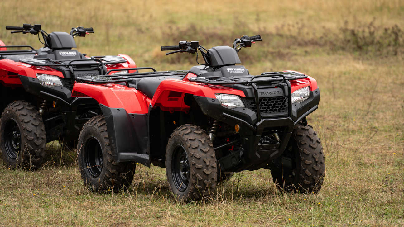 Front three-quarter, left facing Fourtrax 420, being used by model, field location.