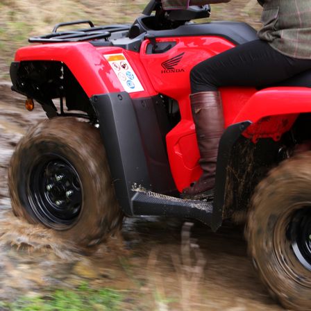 Fourtrax 420 being used by model, forest location.