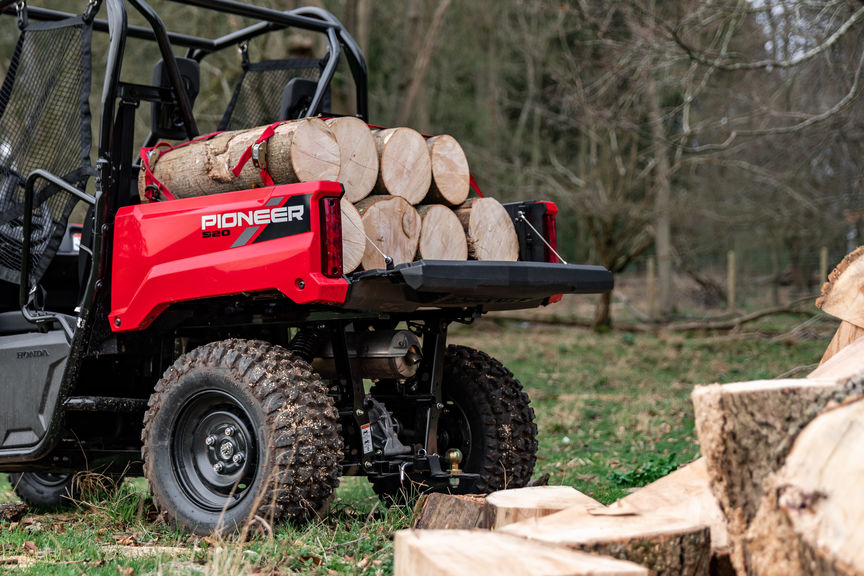Picture of a Honda Pioneer 520 being used to load logs of wood
