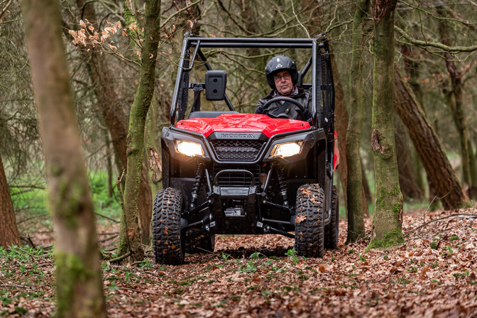 Picture of Honda Pioneer 520 being driven across a wooded landscape