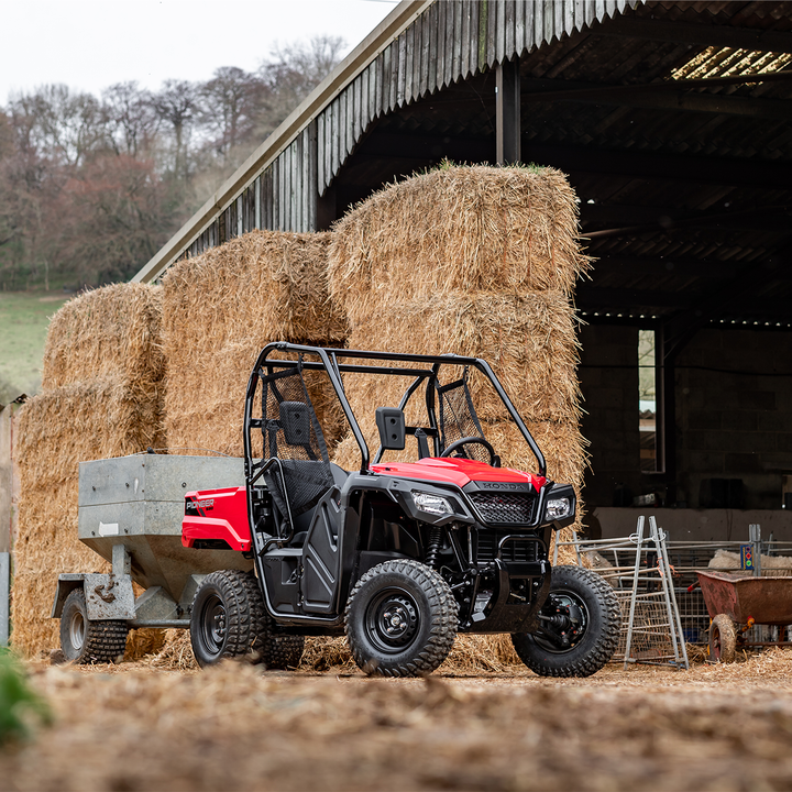 Honda Pioneer 520 shown on a farm near bales of hay