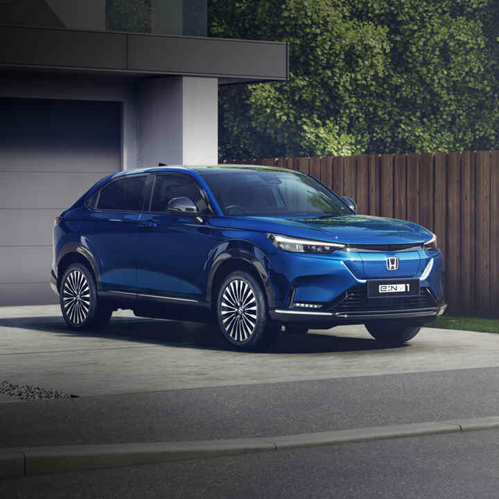 Front facing three quarter Honda e:Ny1 on a driveway.