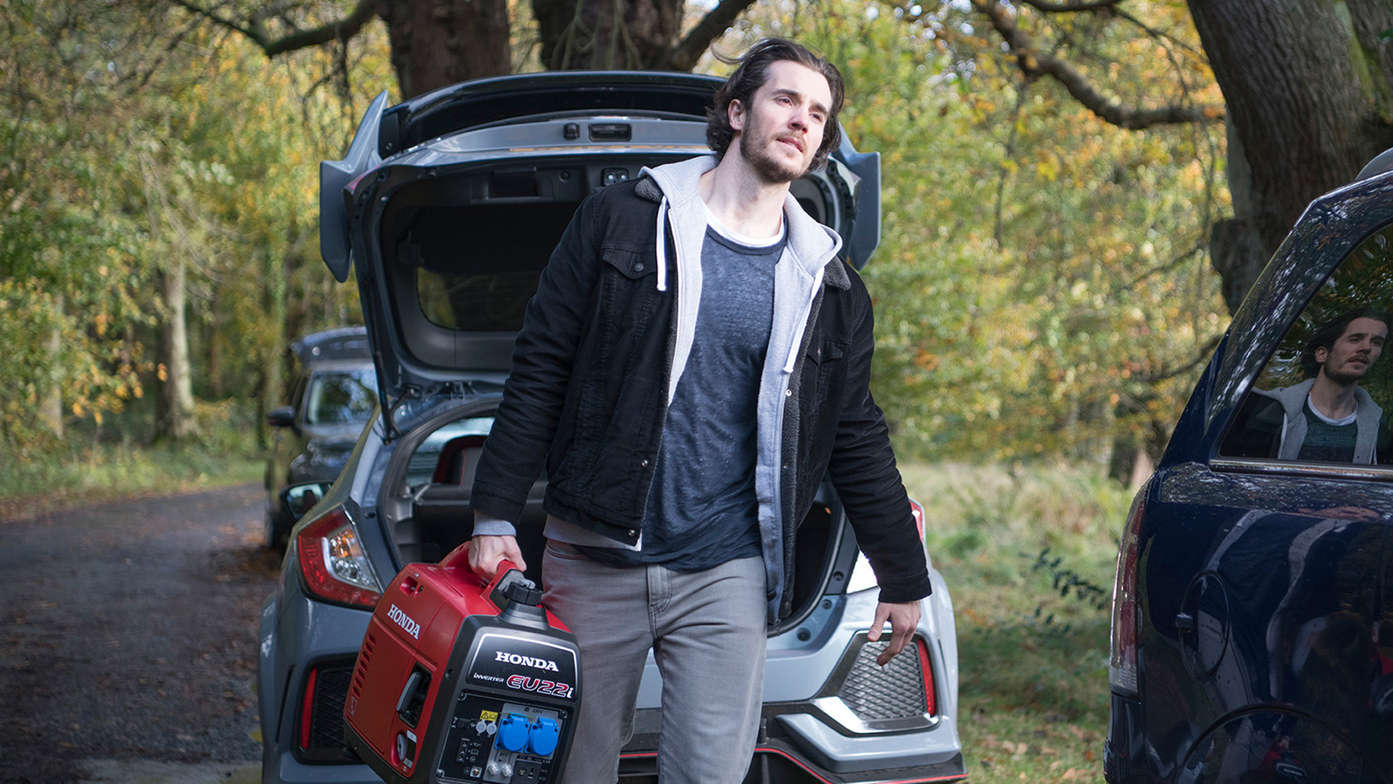 a man carrying eu22i lightweight and portable inverter generator