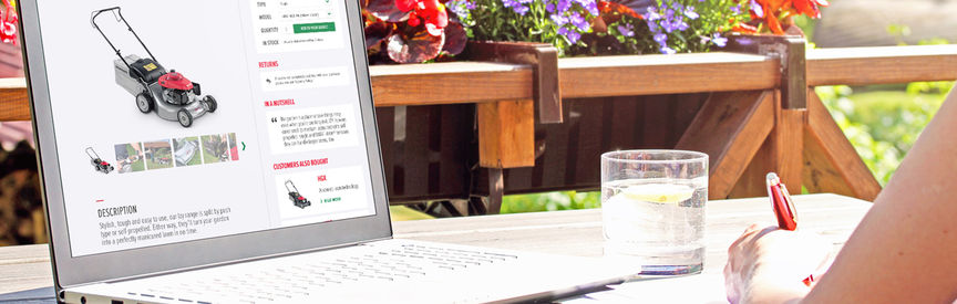 Desk in garden with laptop on it displaying Honda Lawn and Garden website.