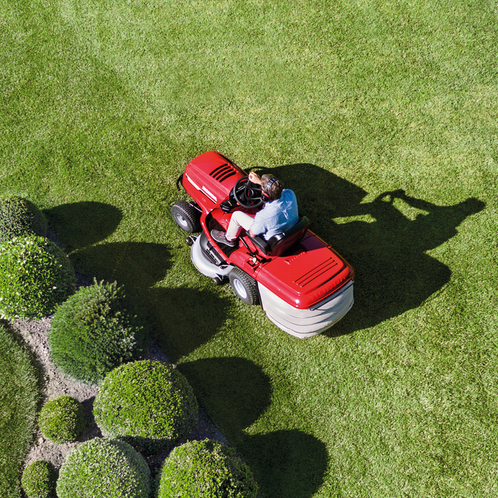 Top view of man riding Honda tractor on grass
