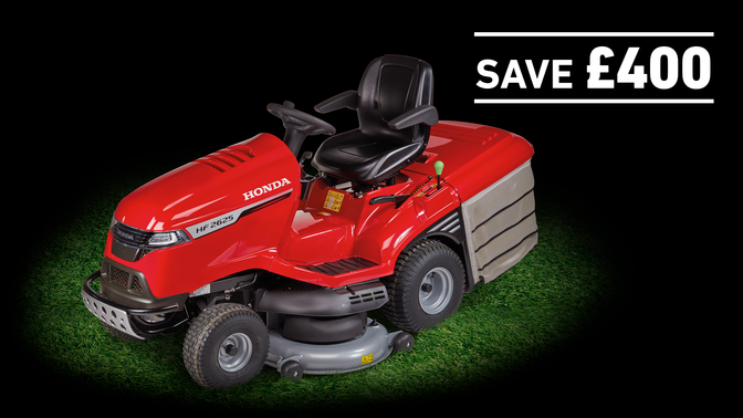 Honda Tractor on grass in a dark background with save £400