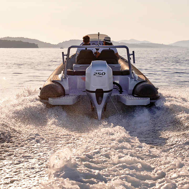 Highfield RIB from behind with a Honda outboard engine, driving away 