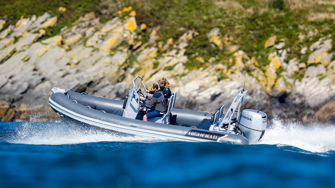 Highfield RIB boat coasting in the water with a couple driving