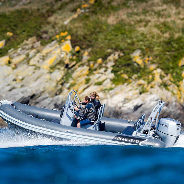 Man and woman driving a Highfield boat with a Honda engine