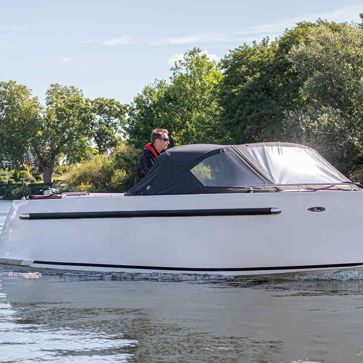 Maxima boat being driven on the thames by a man, with a honda marine outboard engine