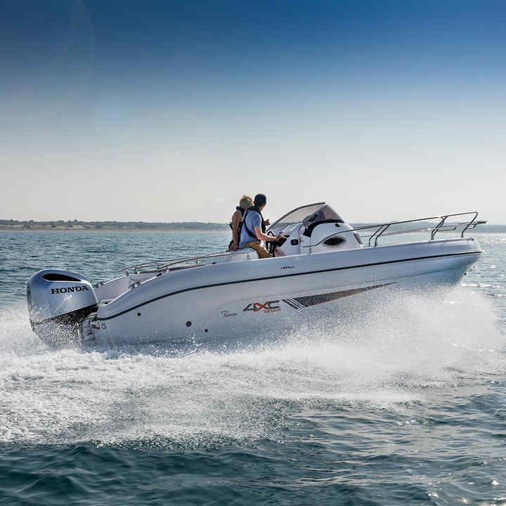 2 people cruising in a Ranieri boat with a Honda engine