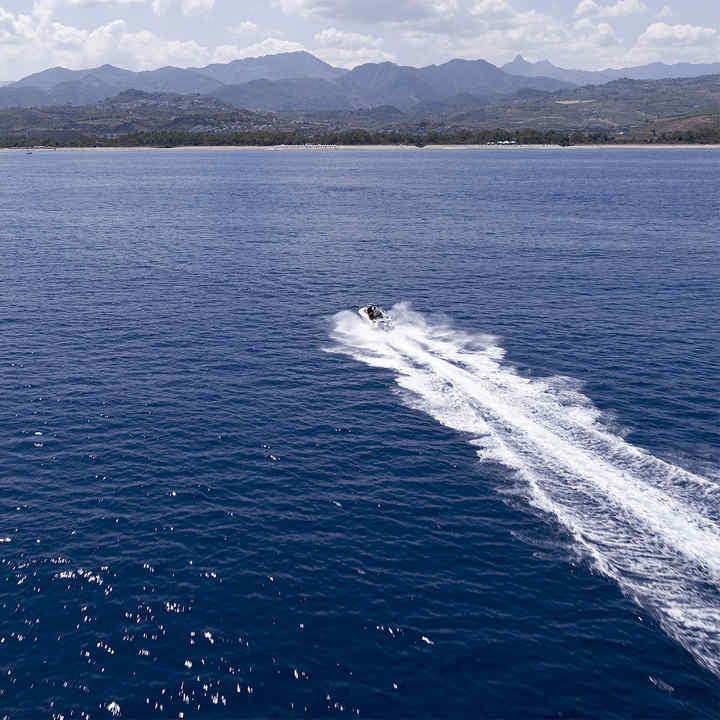 Boat using Honda engine demonstrating performance, being used by model, coastal location.