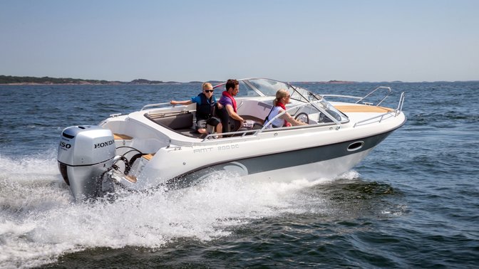side angled view of people steering a boat on the water powered by a honda outboard engine