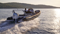 reverse angled view of people steering a highfield boat fitted with a honda marine engine on the water