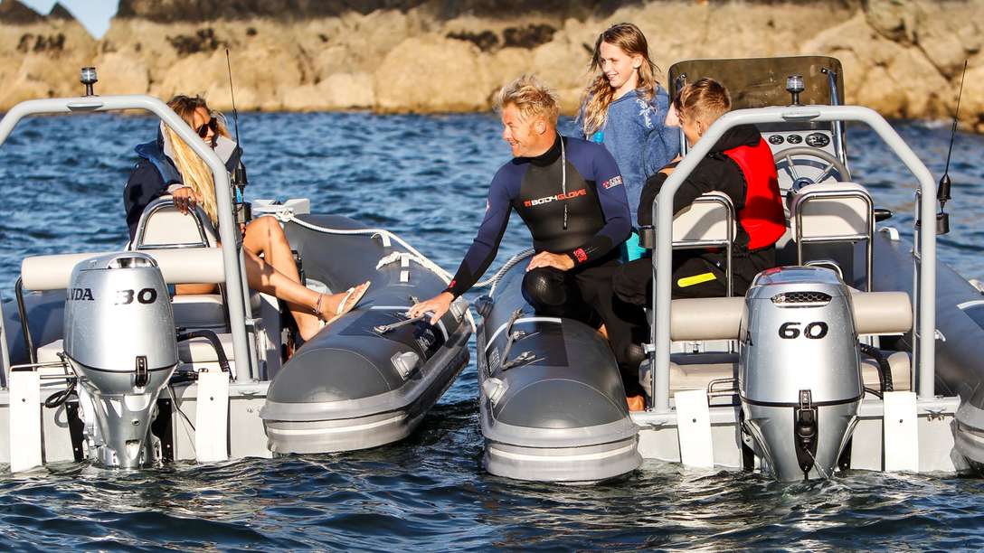 photo of various people in two boats powered by honda outboard engines on the water
