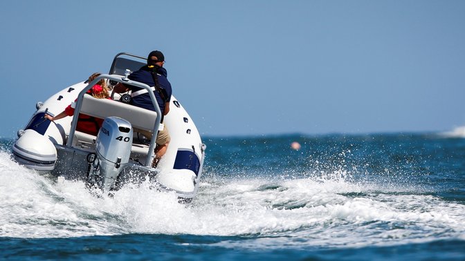 rear view of a man steering a boat fitted with a 40 horsepower honda outboard motor