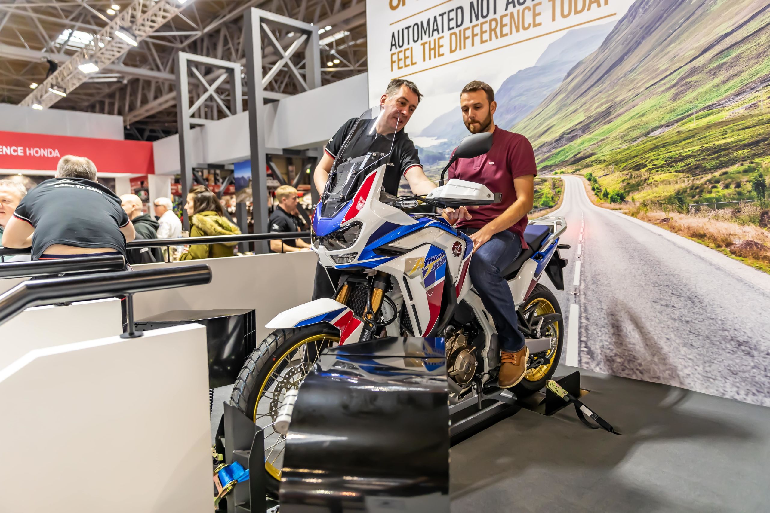 Show visitor sat on 2020 Honda Africa Twin on stand at Motorcycle Live 2019 at Birmingham NEC